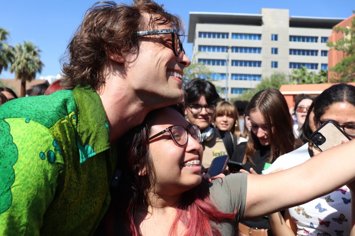 A student excitedly snaps a selfie with Gubler, capturing the special moment.