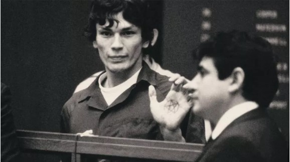 Richard Ramirez shown putting his hand up to show the satanic signs drawn on his hand in court in Episode 4 of Netflixs documentary series Night Stalker.
Image property of Netflix