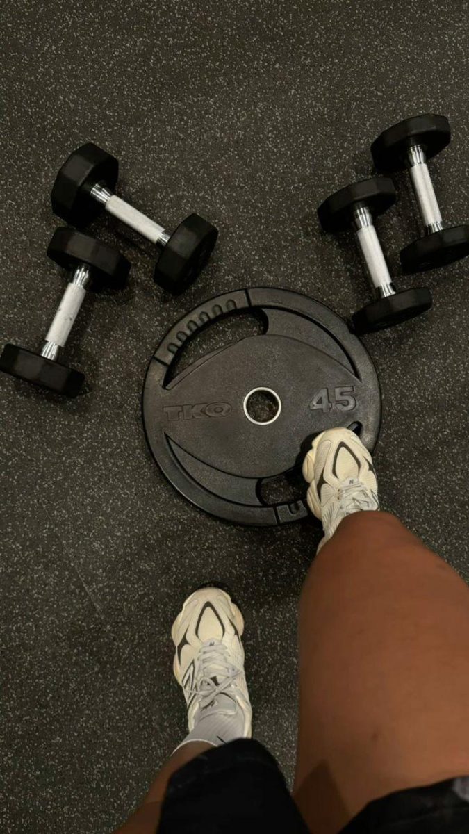 Free weights on the floor represent the physical effort and repetition of working out every day.